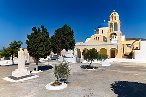 Traditional Greek church blue dome bell tower sunny day.