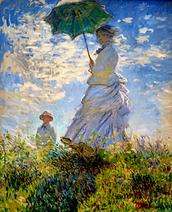 Woman holds a green parasol while standing in a field