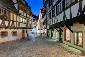 People walk in Petit France district of Strasbourg at dusk