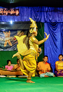 Girl performs traditional Cambodian dance in golden costume.