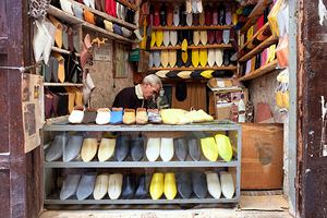 Moroccan babouches shoes in a Fez shop with a vendor