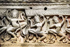Ancient stone carvings of dancing Apsaras on a temple wall.