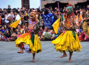 Colorful masked dancers perform barefoot at a festival. by Marco Brivio