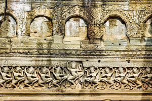 Ancient Khmer temple wall with dancing Apsara bas reliefs.