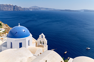 Santorini blue domed church overlooking the Aegean Sea and calde