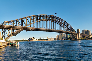 Sydney Harbour Bridge and Opera House under clear blue sky.