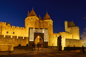 Visit to Carcassonne castle at night with lights around entryway