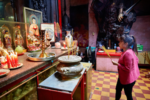 Woman praying at temple in Ho Chi Minh City in Vietnam