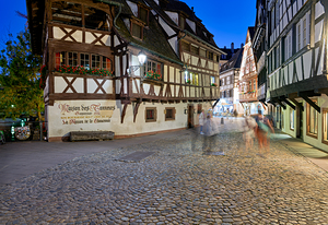 Colorful timber houses and people walking in Strasbourg at night
