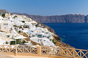 Santorini village on cliff overlooking blue sea.