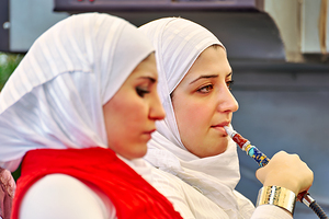 Young woman smokes hookah in Aleppo Syria by Marco Brivio