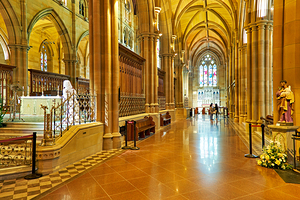 Interior of a grand cathedral with stained glass windows.