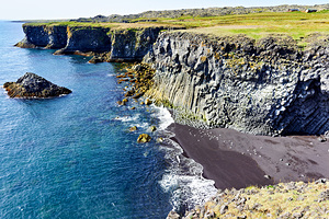 View of Arnarstapi cliffs and black sand beach in Iceland