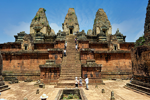 Tourists explore ancient Cambodian temple ruins.