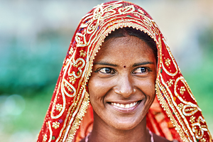 Woman in red traditional dress smiles in Rajasthan