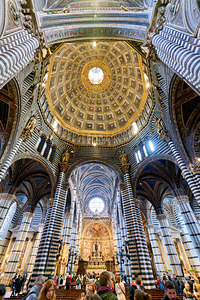 Siena cathedral in Tuscany with visitors exploring inside