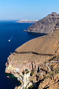 Santorini caldera with cliffs deep blue sea port and distant 