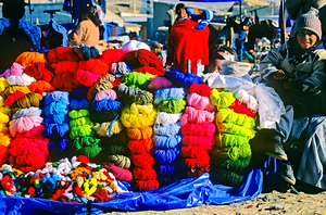 Vibrant market stall with colorful yarn and a smiling child.