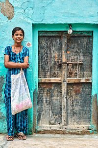 Girl standing in front of a door at her home in Mandawa India