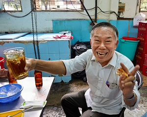 Man enjoying drink and food at cafe in Ho Chi Minh City