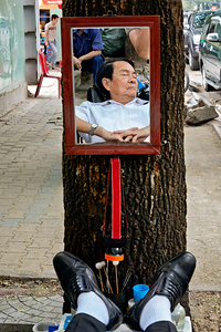 Man resting in Ho Chi Minh City with mirror reflection
