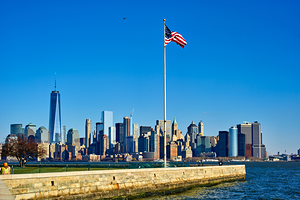 Manhattan skyline view from Liberty Island with American flag