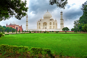 Visit to Taj Mahal in Agra India with green lawns and cloudy ski
