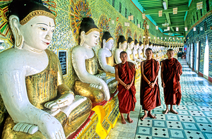 Monks stand by statues in Sagaing Paya in Myanmar