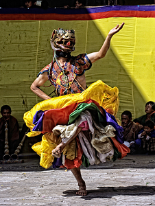 Vibrant masked dancer performs traditional dance.