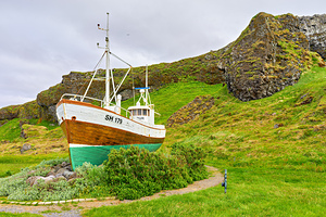 Fishing boat in Olafsvik Iceland near rocky hill