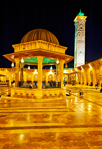 Aleppo mosque at night with lights and visitors in the courtyard by Marco Brivio