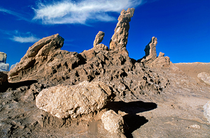 Dramatic desert rock formations under a vibrant blue sky.