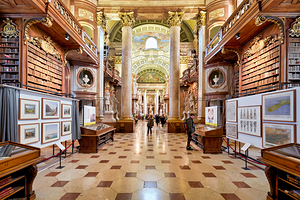 Grand ornate library interior with books columns and visitors
