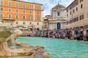 Crowd gathers at Trevi Fountain in Rome Italy on a sunny day