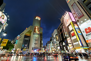 Busy night in Tokyos Shibuya district with bright lights and cr