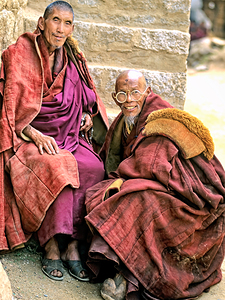 Two smiling elderly monks share a moment in Tibet