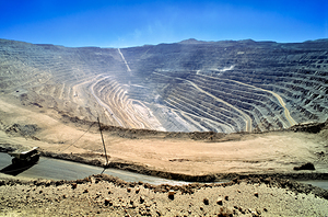 Vast open pit mine with terraced walls and haul truck. by Marco Brivio