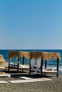 Person relaxing in a beach cabana by the sea.