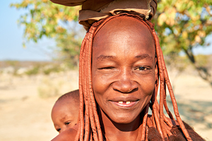 Smiling Himba woman and baby in Kunene region of Namibia