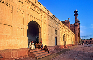 Visitors rest by Badshahi Mosque during sunset in Lahore