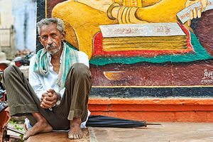 Old man sitting near mural in Bundi Rajasthan India by Marco Brivio