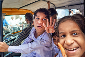 Smiling kids riding in a car in Bundi Rajasthan India