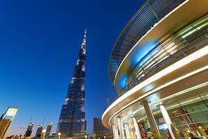 Burj Khalifa at night with modern buildings in Dubai skyline