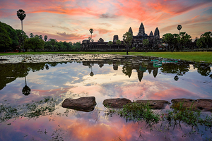 Angkor Wat temple reflected in water at sunset.