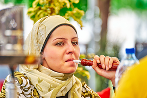 Young woman smokes hookah in Aleppo Syria during a sunny day by Marco Brivio