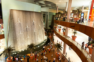 Indoor waterfall with diving figures in Dubai mall during daytim by Marco Brivio