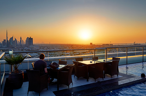 Working on a rooftop with Dubai skyline view at sunset