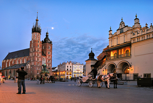Evening in Krakow with horse carriages and a church