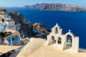 Picturesque Santorini village church bells and deep blue sea.
