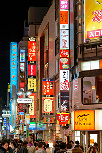 Neon lights illuminate Shibuya district streets in Tokyo at nigh